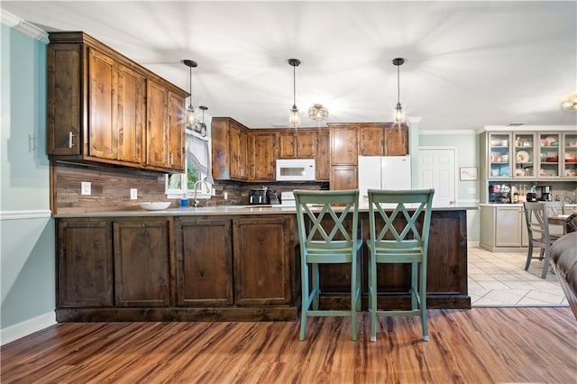 513 Samauri Ct, Saraland, AL 36571 - kitchen featuring white appliances, decorative backsplash, hanging light fixtures, wood finished floors, and crown molding