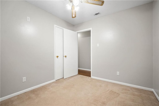 carpeted spare room with ceiling fan