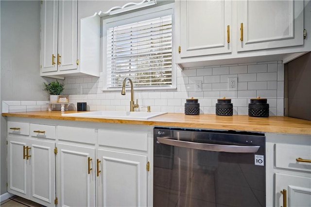 kitchen with tasteful backsplash, stainless steel dishwasher, sink, white cabinetry, and butcher block counters