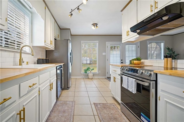 kitchen featuring white cabinetry, black dishwasher, stainless steel range with electric stovetop, butcher block countertops, and light tile patterned floors