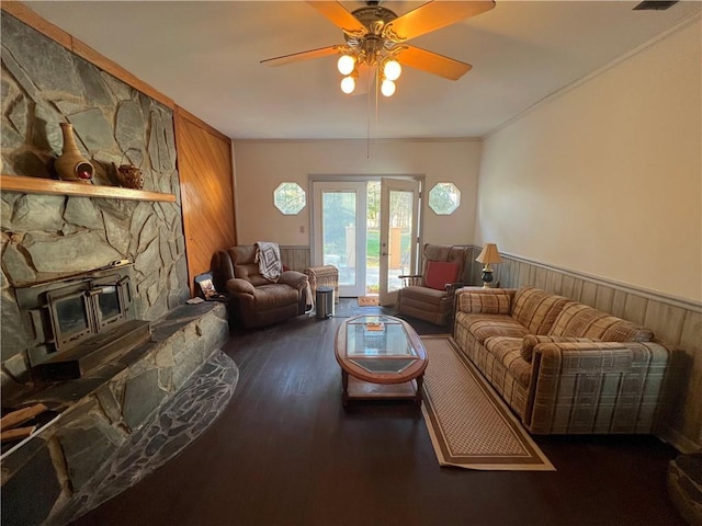 living room with ceiling fan, wood walls, crown molding, and dark hardwood / wood-style floors