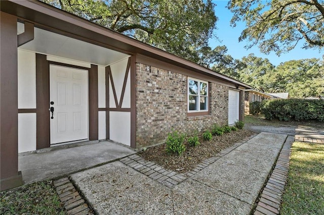 view of exterior entry with brick siding and stucco siding