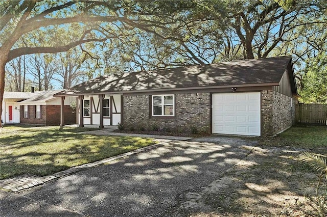 view of front of property featuring a garage, gravel driveway, fence, a front lawn, and brick siding