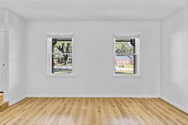 spare room with wood finished floors and baseboards