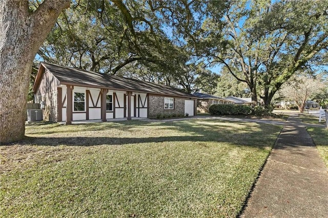 tudor home featuring a front yard and central AC unit