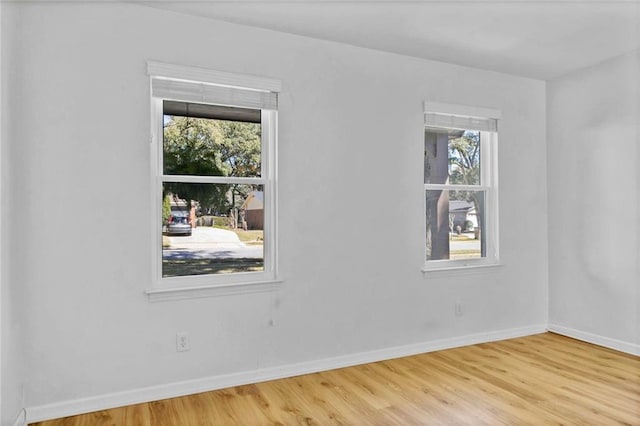 empty room featuring baseboards and wood finished floors