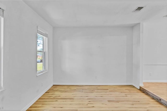 spare room with light wood-type flooring, baseboards, and visible vents