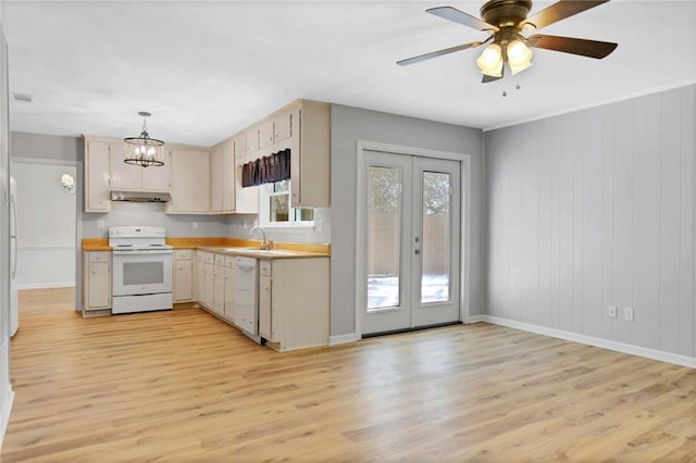 kitchen featuring white appliances, light countertops, light wood-type flooring, under cabinet range hood, and a sink