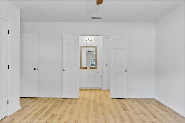 unfurnished bedroom featuring light wood-style floors, baseboards, visible vents, and ceiling fan