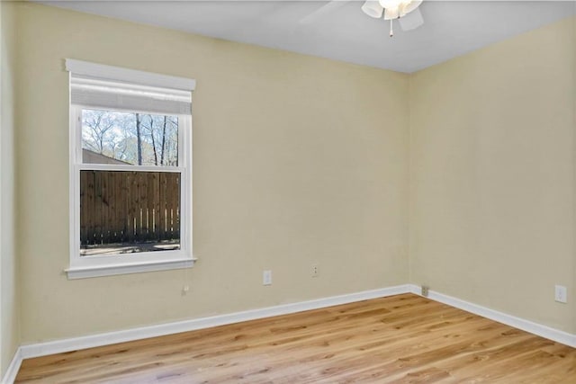 unfurnished room featuring a ceiling fan, baseboards, and wood finished floors