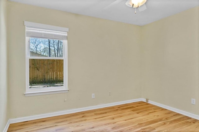 spare room with ceiling fan, baseboards, and wood finished floors