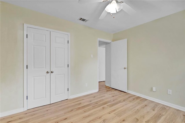 unfurnished bedroom featuring a closet, visible vents, ceiling fan, wood finished floors, and baseboards