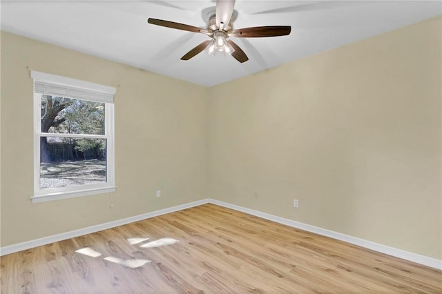 spare room with a ceiling fan, light wood-style flooring, and baseboards