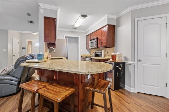 kitchen with crown molding, stainless steel appliances, visible vents, backsplash, and open floor plan