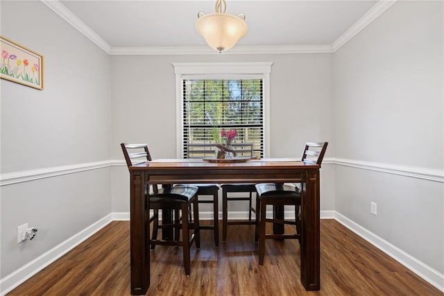 dining area featuring crown molding, wood finished floors, and baseboards