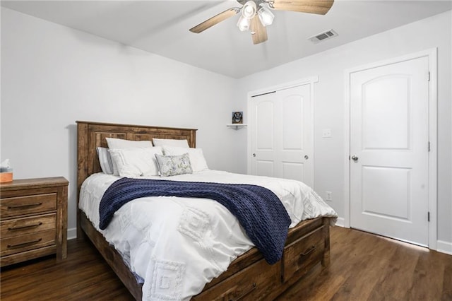 bedroom featuring a ceiling fan, a closet, visible vents, and dark wood-type flooring