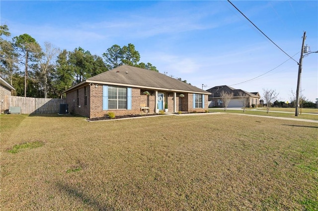 ranch-style home featuring central air condition unit, fence, a front lawn, and brick siding