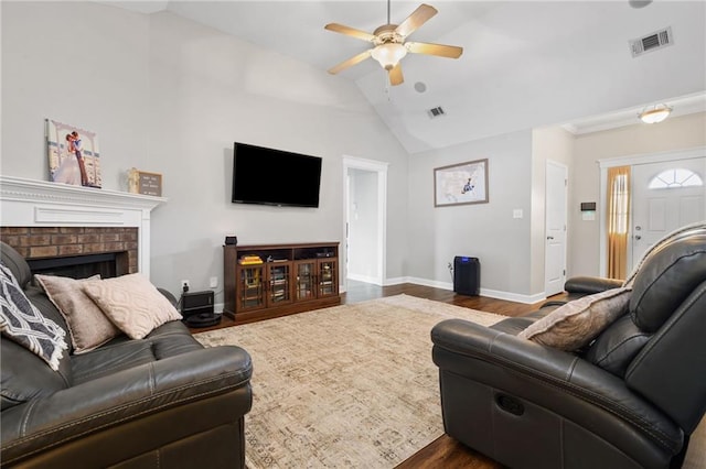 living room with dark wood finished floors, lofted ceiling, visible vents, a ceiling fan, and baseboards