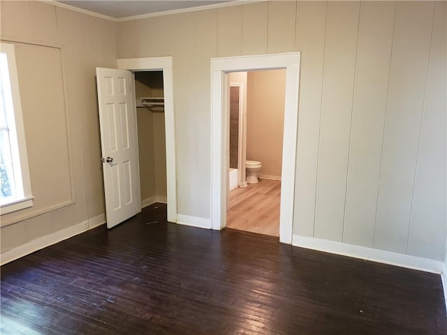 unfurnished bedroom featuring dark hardwood / wood-style floors and ornamental molding