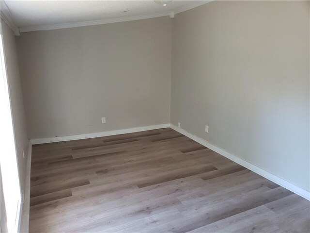 unfurnished room featuring light hardwood / wood-style floors and ornamental molding