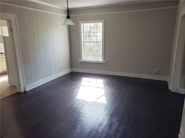 spare room with dark hardwood / wood-style floors, wood walls, and ornamental molding