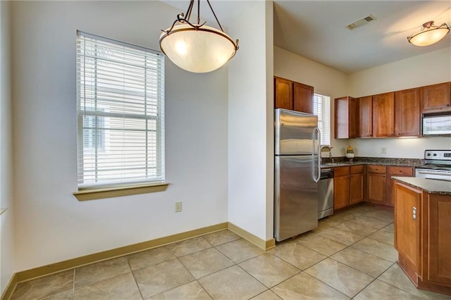 1430 Regency Rd Unit F204, Gulf Shores, AL 36542 - kitchen with stainless steel appliances, brown cabinets, baseboards, a sink, and light tile patterned flooring