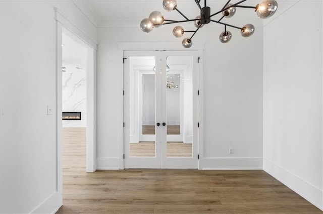 interior space with ornamental molding, wood-type flooring, and french doors