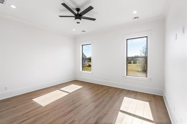 spare room with light hardwood / wood-style floors, ceiling fan, and plenty of natural light