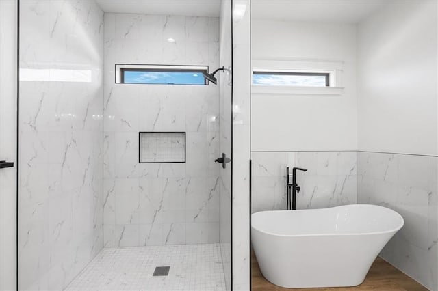 bathroom featuring tile walls, wood-type flooring, and separate shower and tub