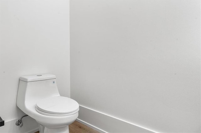 bathroom featuring wood-type flooring and toilet