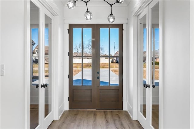 doorway to outside featuring french doors and light hardwood / wood-style flooring