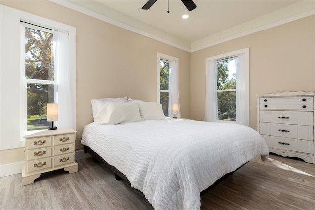 bedroom featuring ornamental molding, recessed lighting, multiple windows, and wood finished floors