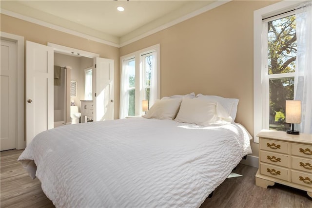 bedroom with dark wood finished floors and crown molding