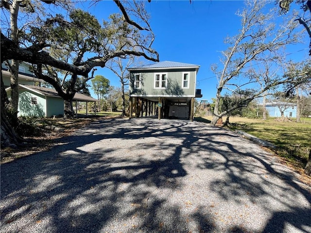 view of home's exterior with a carport, gravel driveway, and metal roof