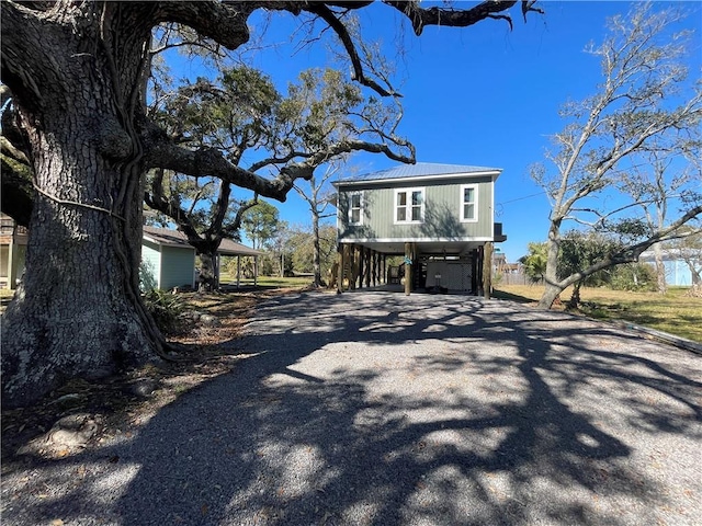 view of front of property featuring metal roof, a carport, and gravel driveway