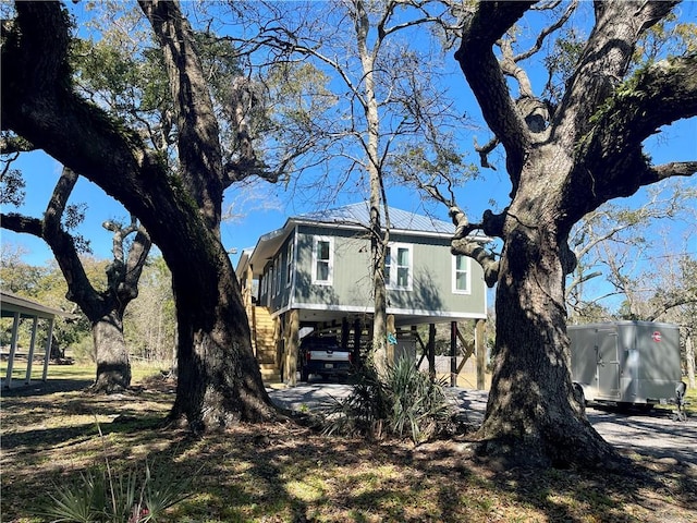 view of side of property featuring dirt driveway and a carport