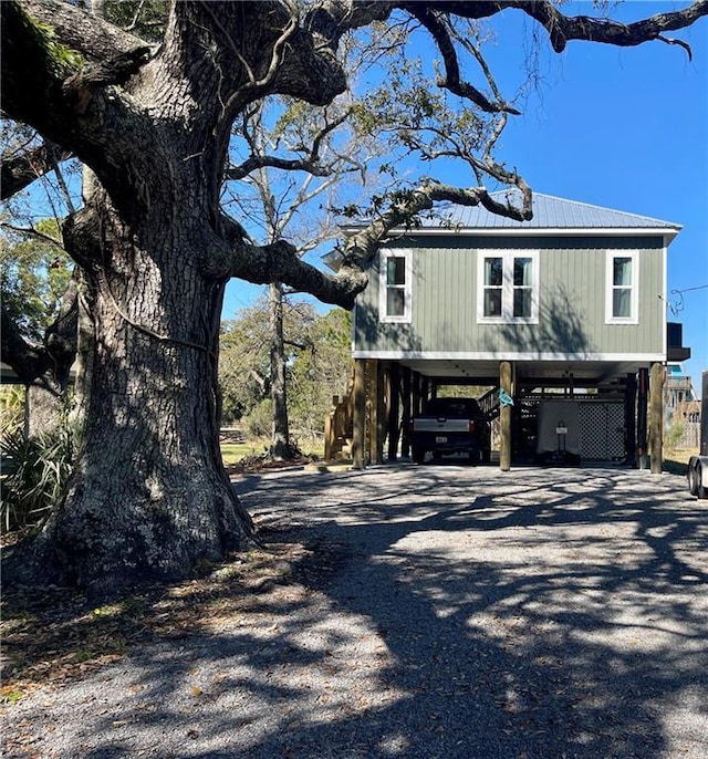 view of property exterior featuring a carport, metal roof, and driveway