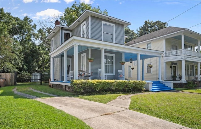 view of front of home featuring a front lawn, a porch, and a balcony