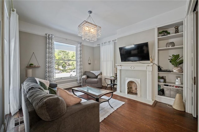 living room featuring a notable chandelier, hardwood / wood-style floors, and built in features