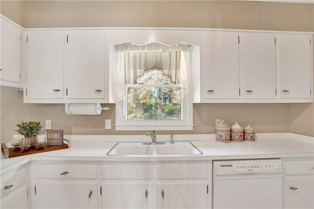 kitchen with dishwasher, white cabinetry, and a sink