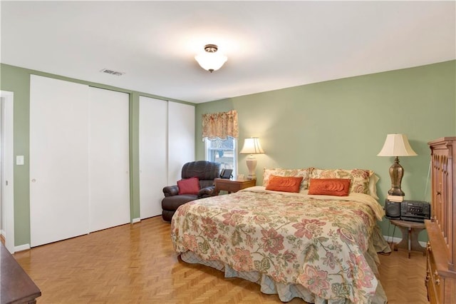 bedroom with visible vents and two closets