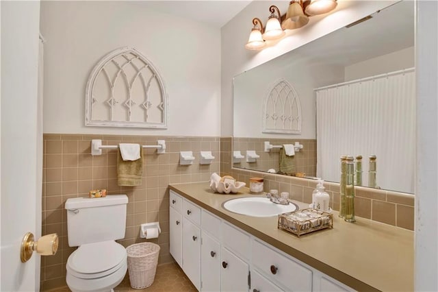 full bath with vanity, tile walls, toilet, and wainscoting