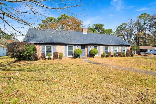 ranch-style house featuring a front yard, brick siding, and a chimney