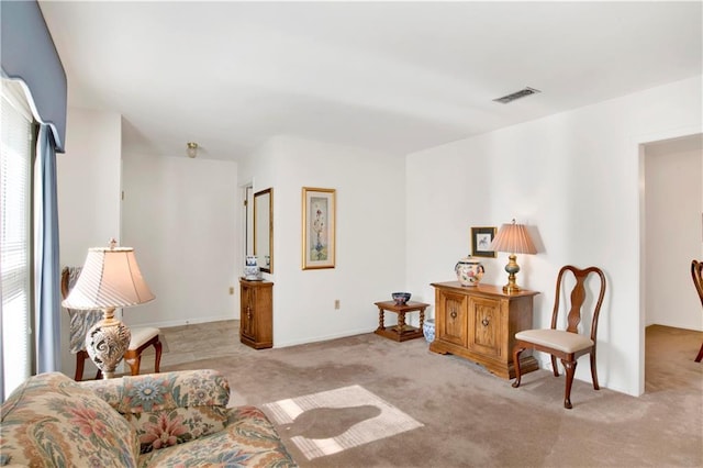 sitting room featuring visible vents, a healthy amount of sunlight, and light colored carpet