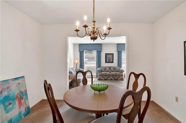 dining area with baseboards, a chandelier, and carpet flooring