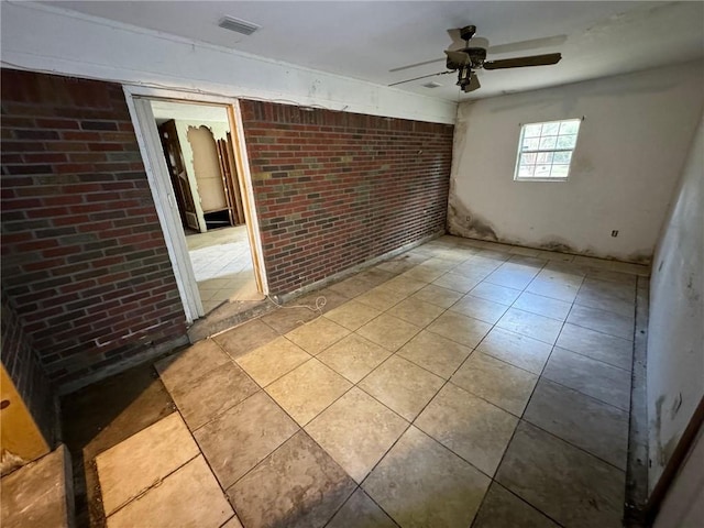 spare room with brick wall and ceiling fan