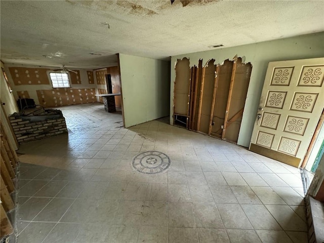 unfurnished room featuring a textured ceiling and ceiling fan