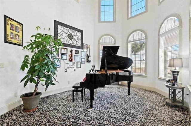 sitting room featuring baseboards and a high ceiling