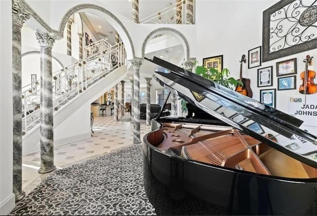 interior space featuring ornate columns, stairs, and a high ceiling