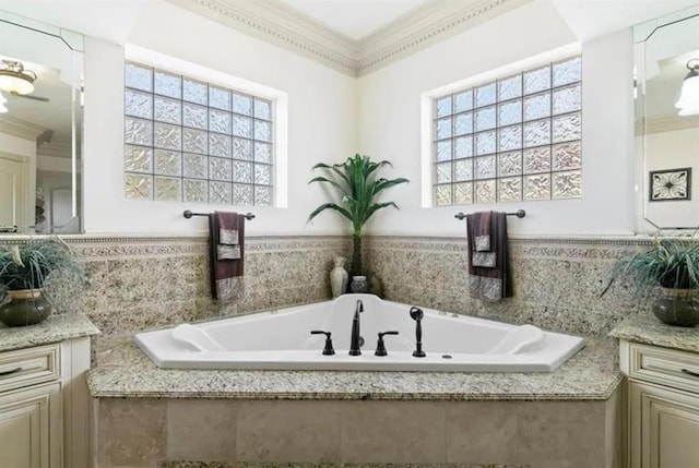 full bathroom featuring a bath, crown molding, and vanity